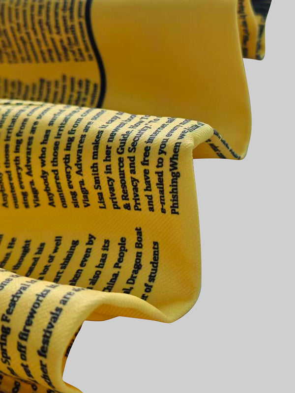 Fitted yellow blazer printed with newspaper columns and a peak lapel