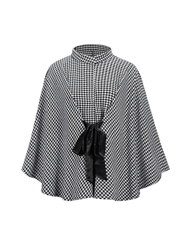 Black and white houndstooth cape coat with a stand collar and tie belt