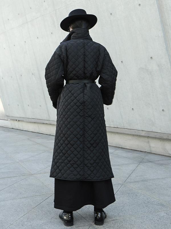 Long black quilted wrap coat with a fold-over collar and ring-buckle belt