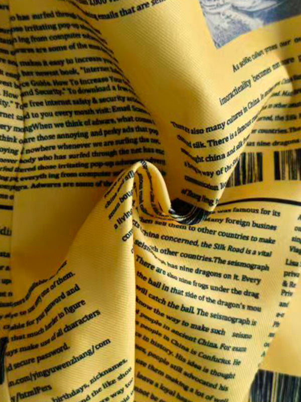 Fitted yellow blazer printed with newspaper columns and a peak lapel