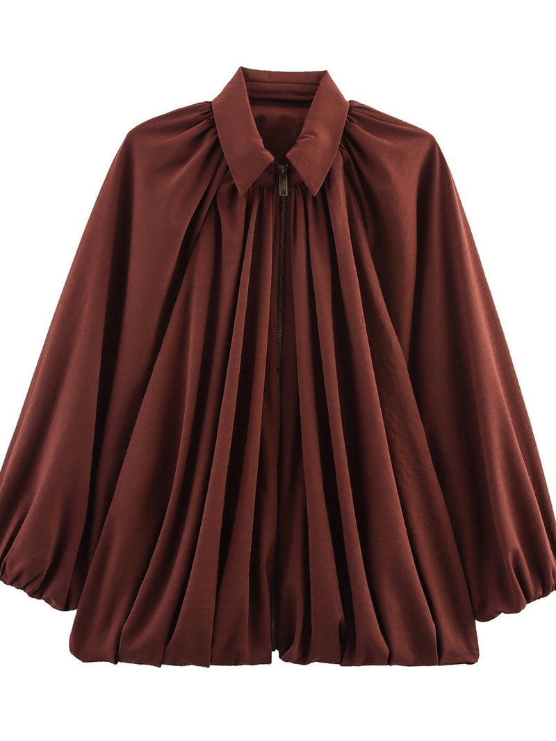 Cape jacket falling in soft pleats with a zip front and pointed collar in rust