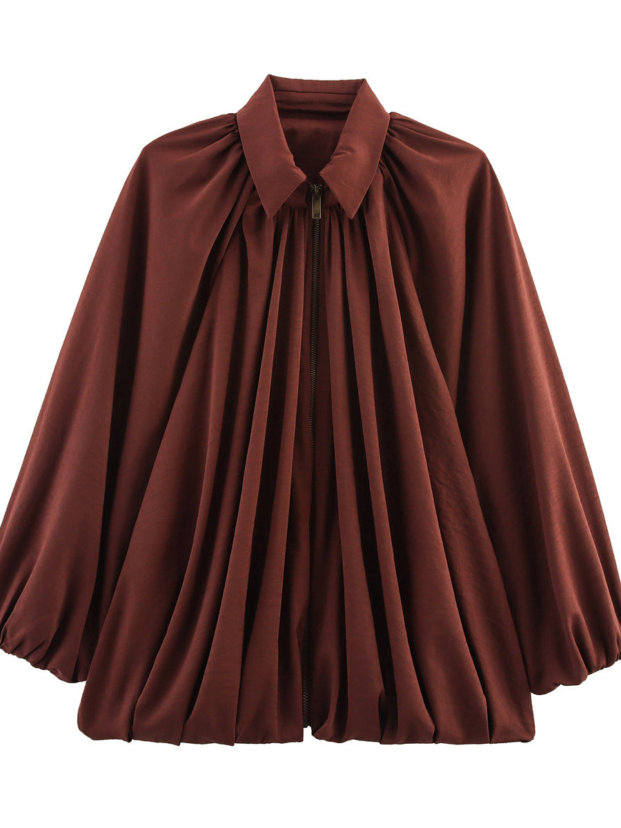 Cape jacket falling in soft pleats with a zip front and pointed collar in rust