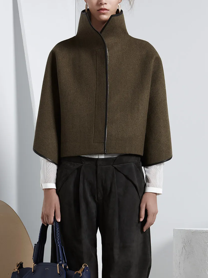 Cropped cape jacket with a high stand collar and contrast edging in green
