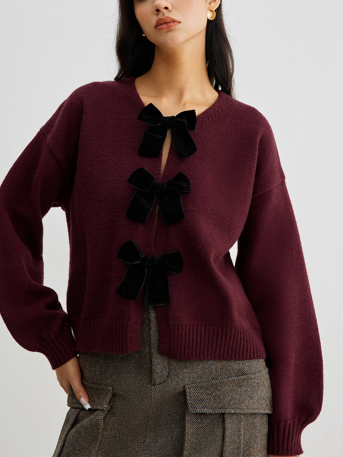 Women's short cardigan with three black bows and a crew neck