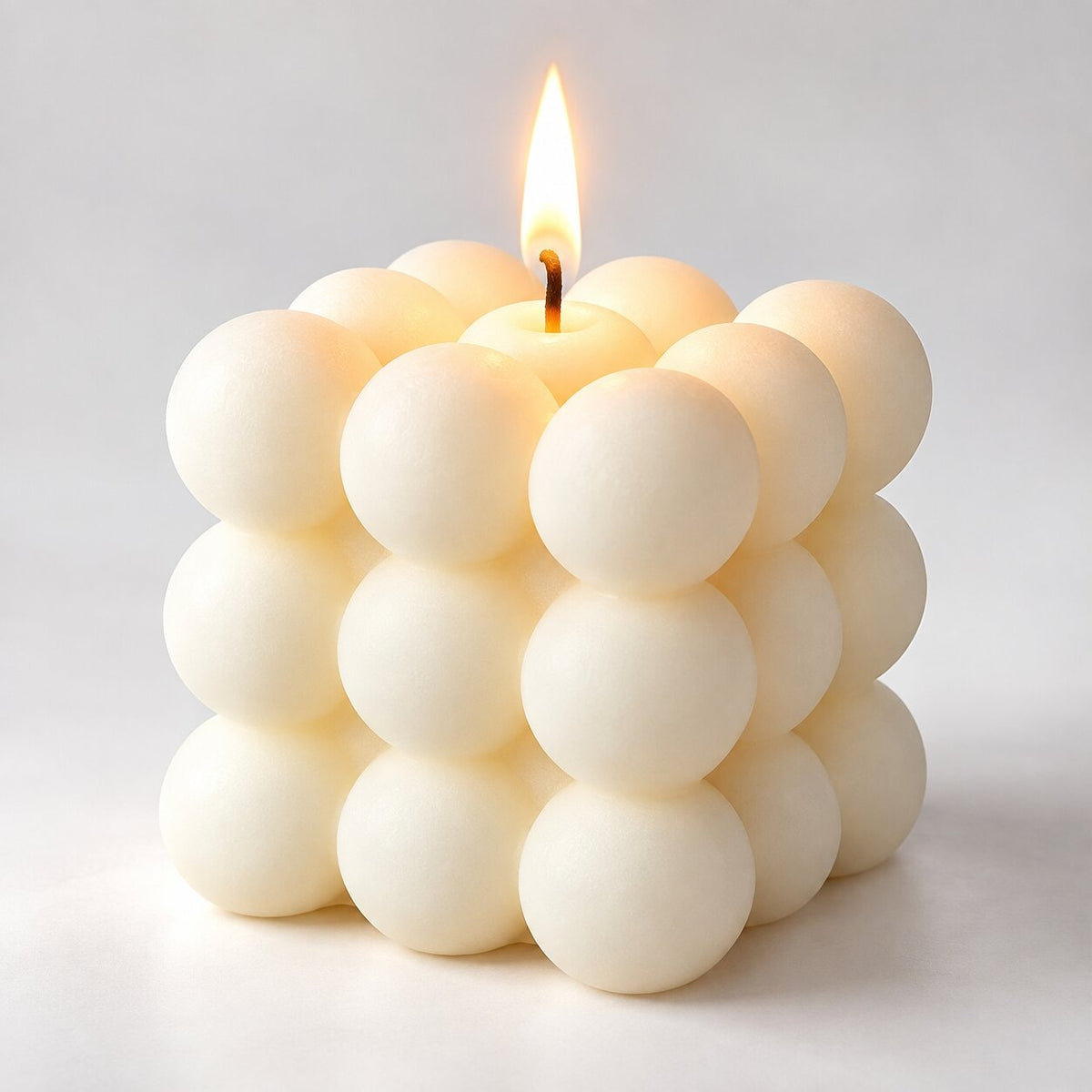 Bubble cube candle with a lit wick - cream
