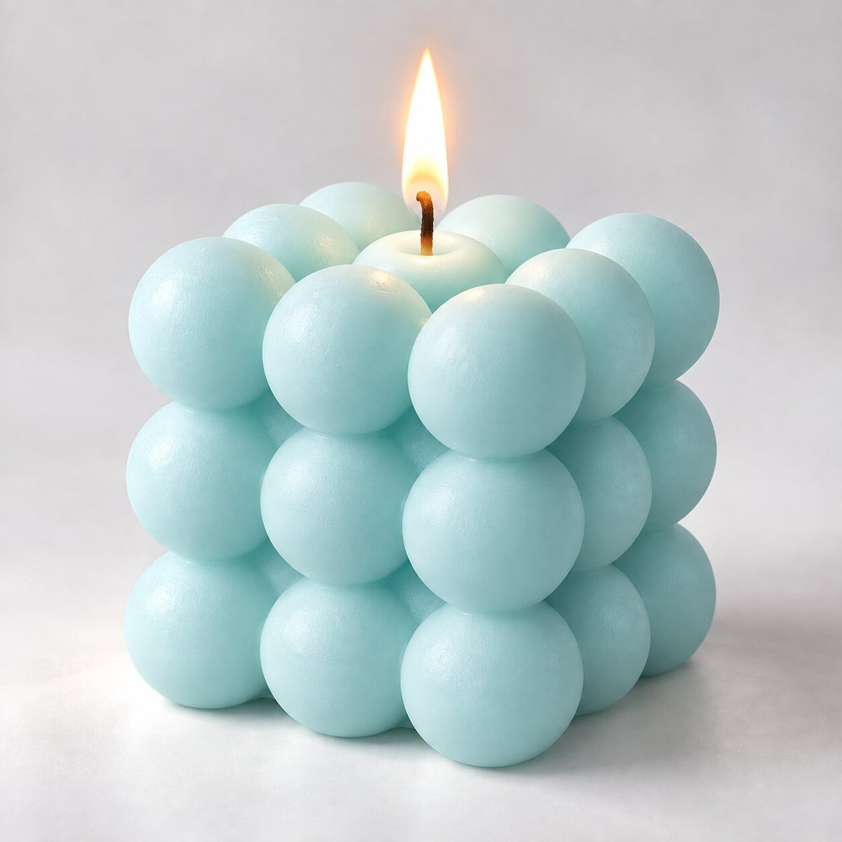 Bubble cube candle with a lit wick - light blue
