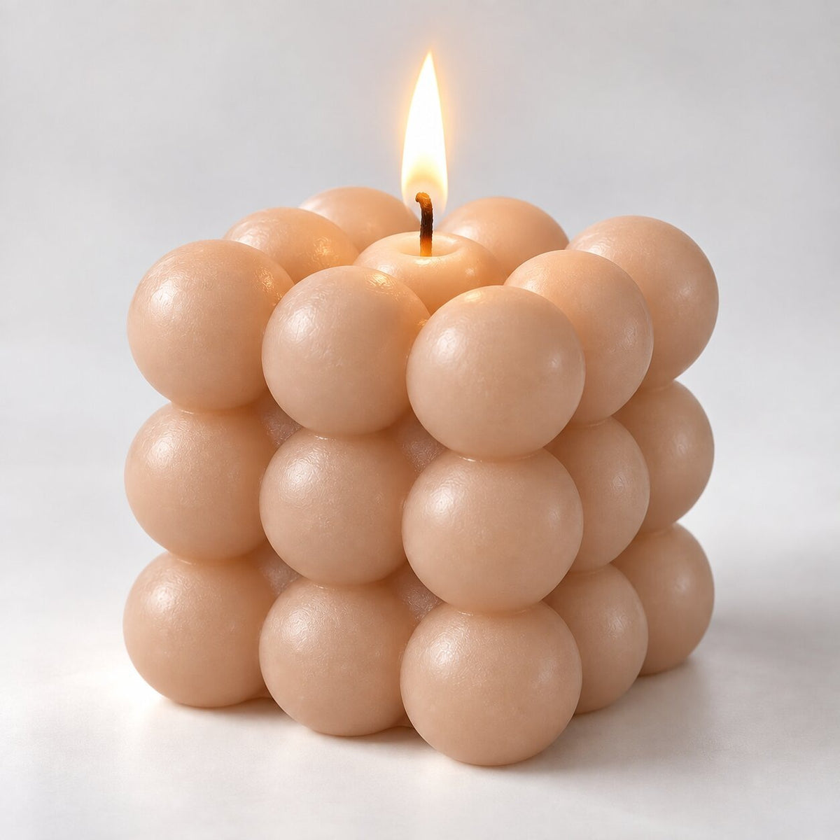 Bubble cube candle with a lit wick - light brown