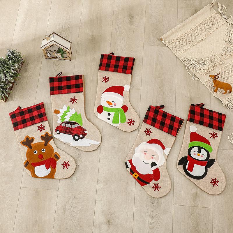 Burlap-look Christmas stocking with a red and black check cuff and a character