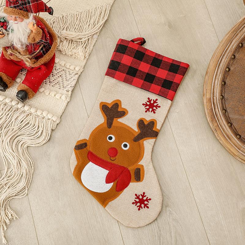 Burlap-look Christmas stocking with a red and black check cuff and a character - reindeer