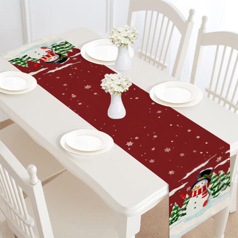 Christmas table runner, 30 x 180 cm, with a festive print on a laid table - dark red with snowman