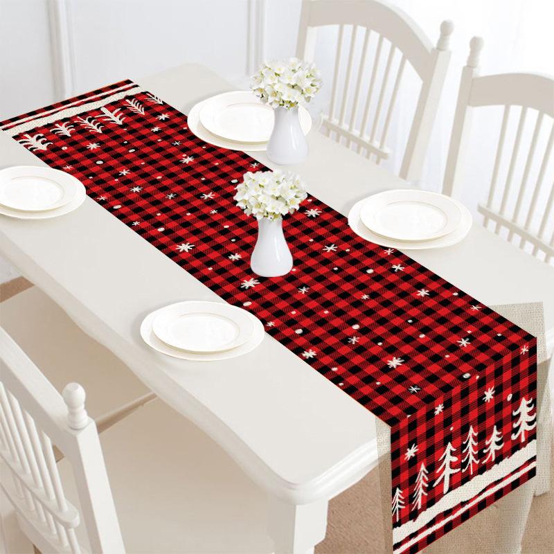 Christmas table runner, 30 x 180 cm, with a festive print on a laid table - red check with white trees