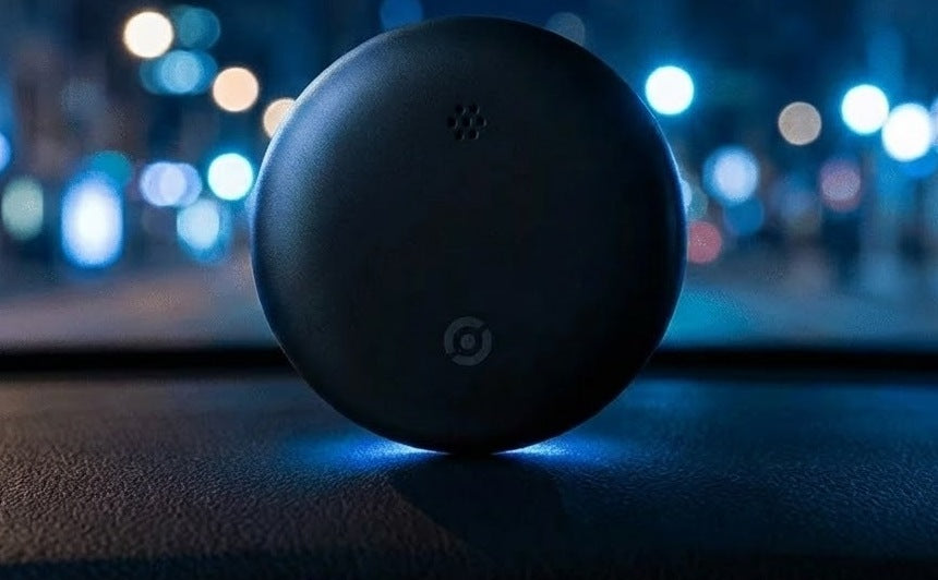 Compact round GPS tracker for the car with the app on a phone