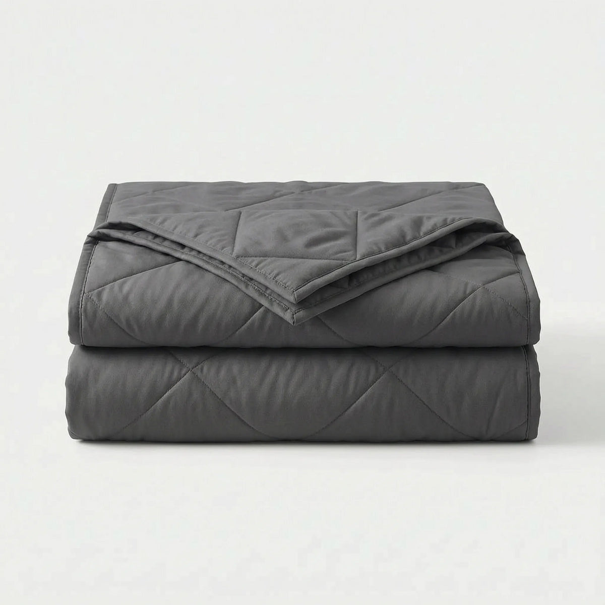 Light cooling blanket with diamond stitching over a made bed - dark grey