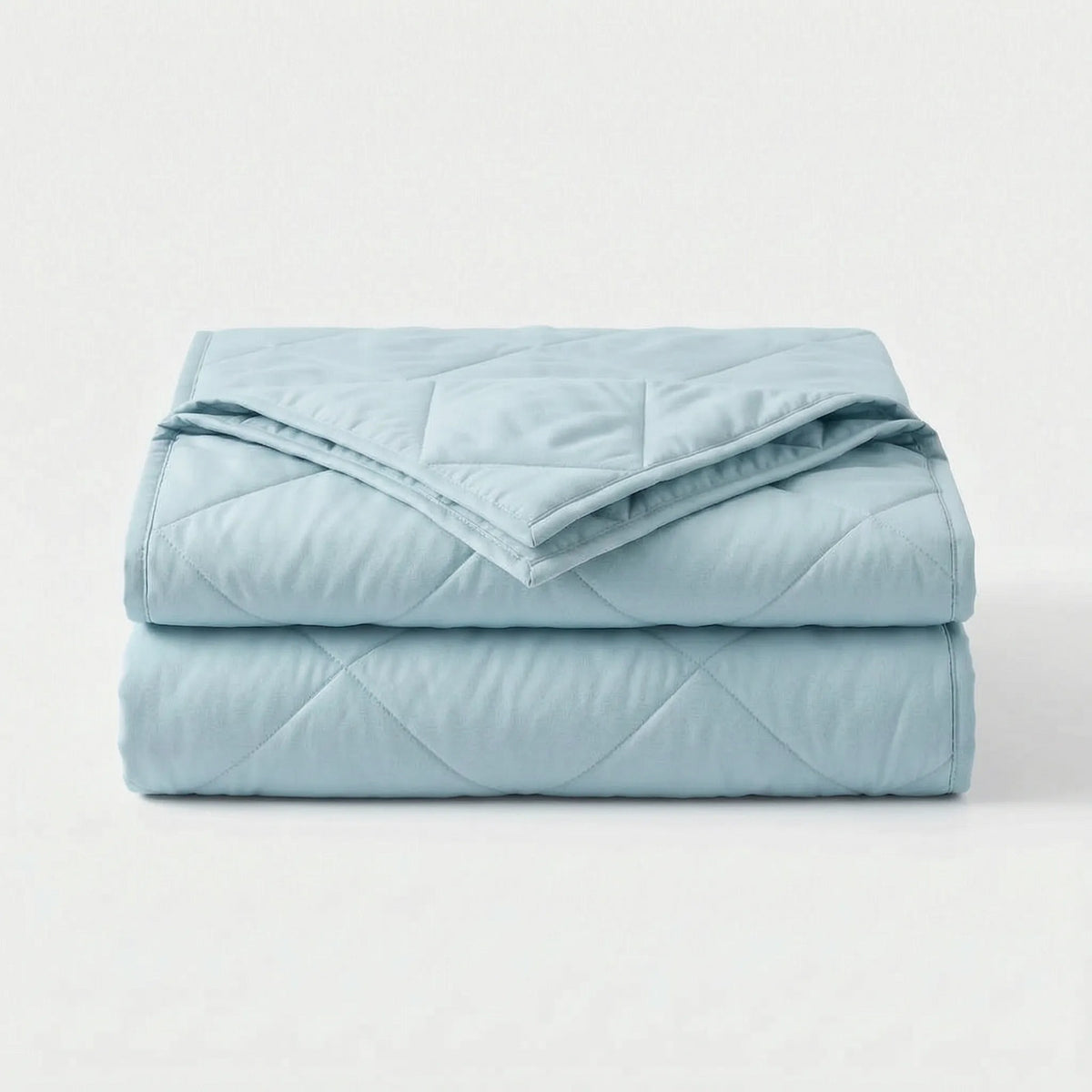 Light cooling blanket with diamond stitching over a made bed - light blue