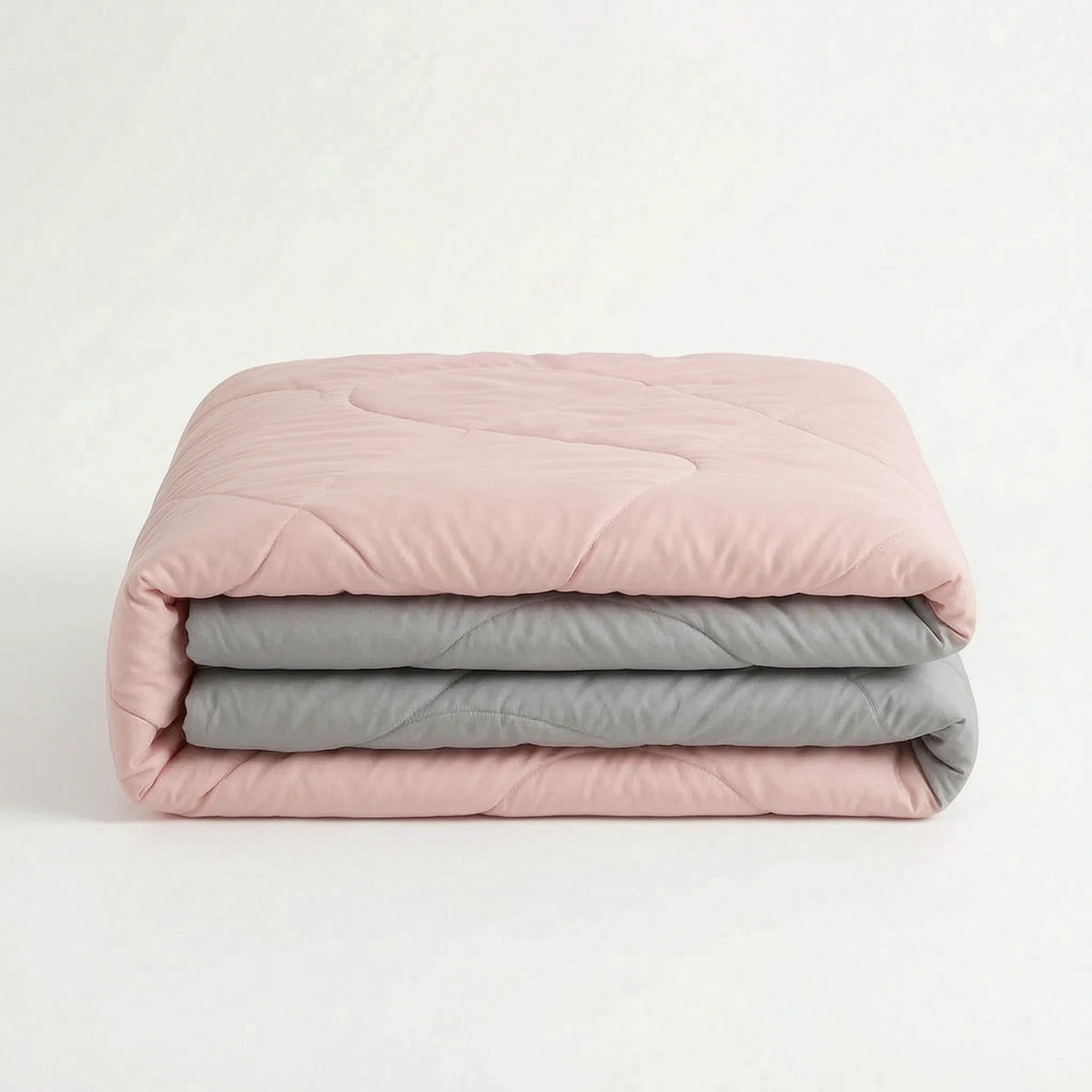 Light cooling duvet without a cover on a bed - pink/grey