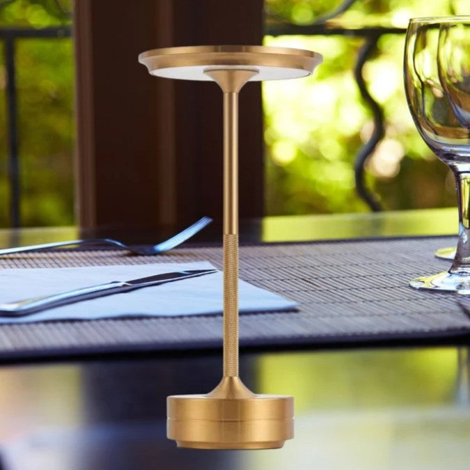 Cordless aluminium table lamp with a flat round shade, slim stem and round base - gold