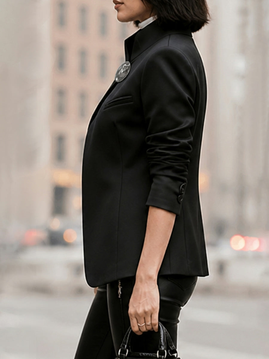 Black asymmetric jacket with a stand collar and a round clasp at the neck