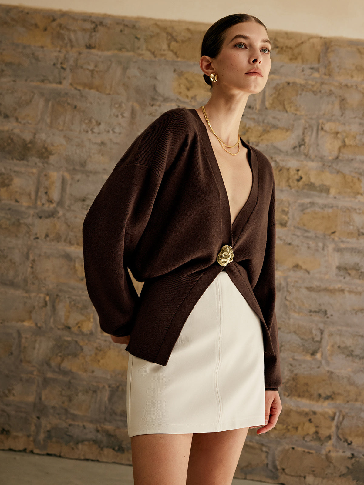 Women's deep V-neck cardigan with a single gold-tone button at the waist
