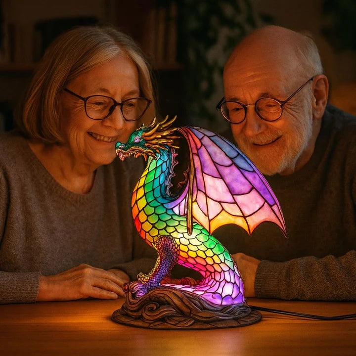 Dragon lamp in a stained glass look with rainbow scales and pink wings on a base with waves
