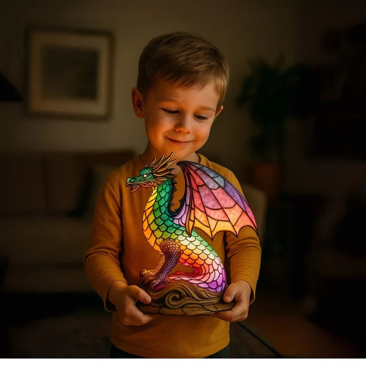 Dragon lamp in a stained glass look with rainbow scales and pink wings on a base with waves