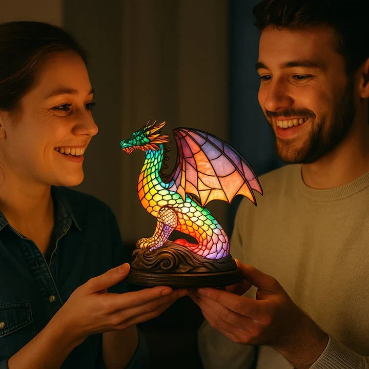 Dragon lamp in a stained glass look with rainbow scales and pink wings on a base with waves