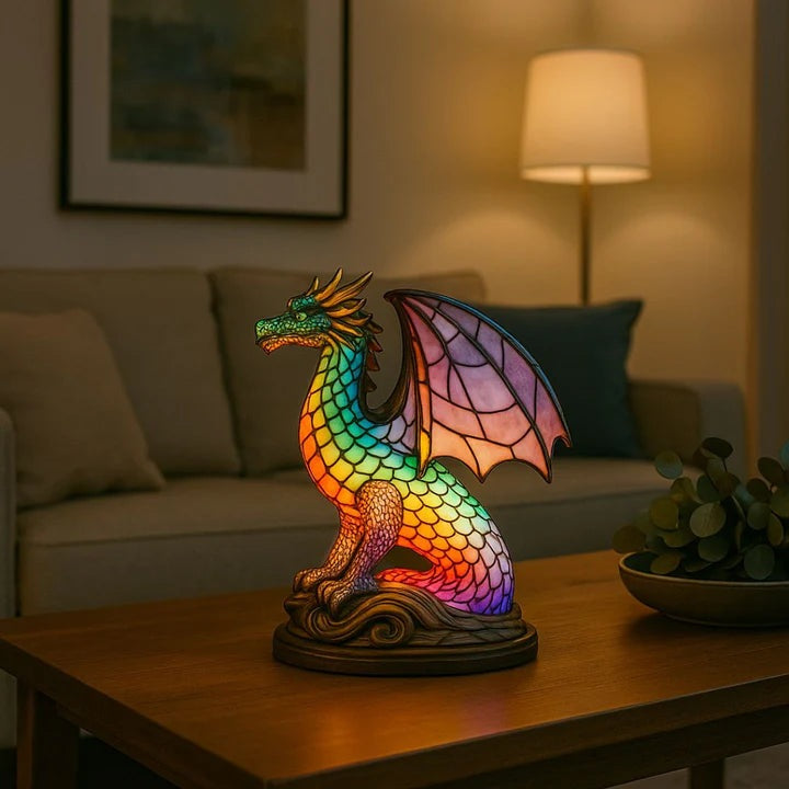 Dragon lamp in a stained glass look with rainbow scales and pink wings on a base with waves