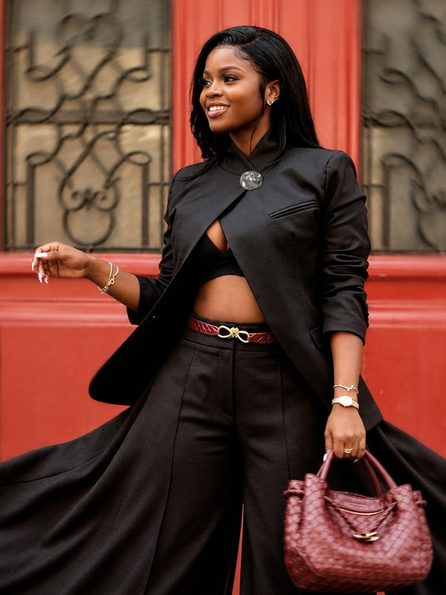 Black asymmetric jacket with a stand collar and a round clasp at the neck