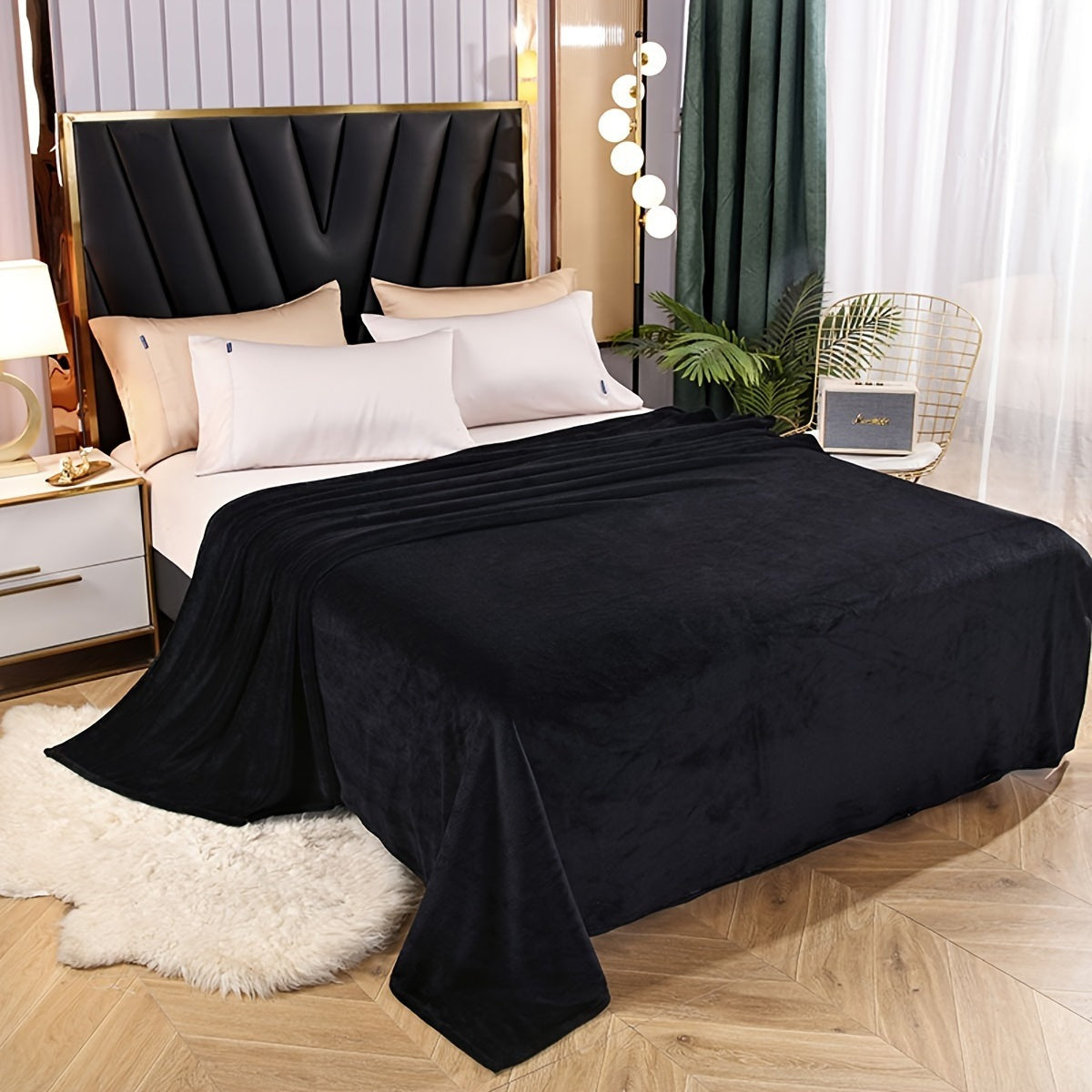 Plain flannel fleece blanket over a bed - black