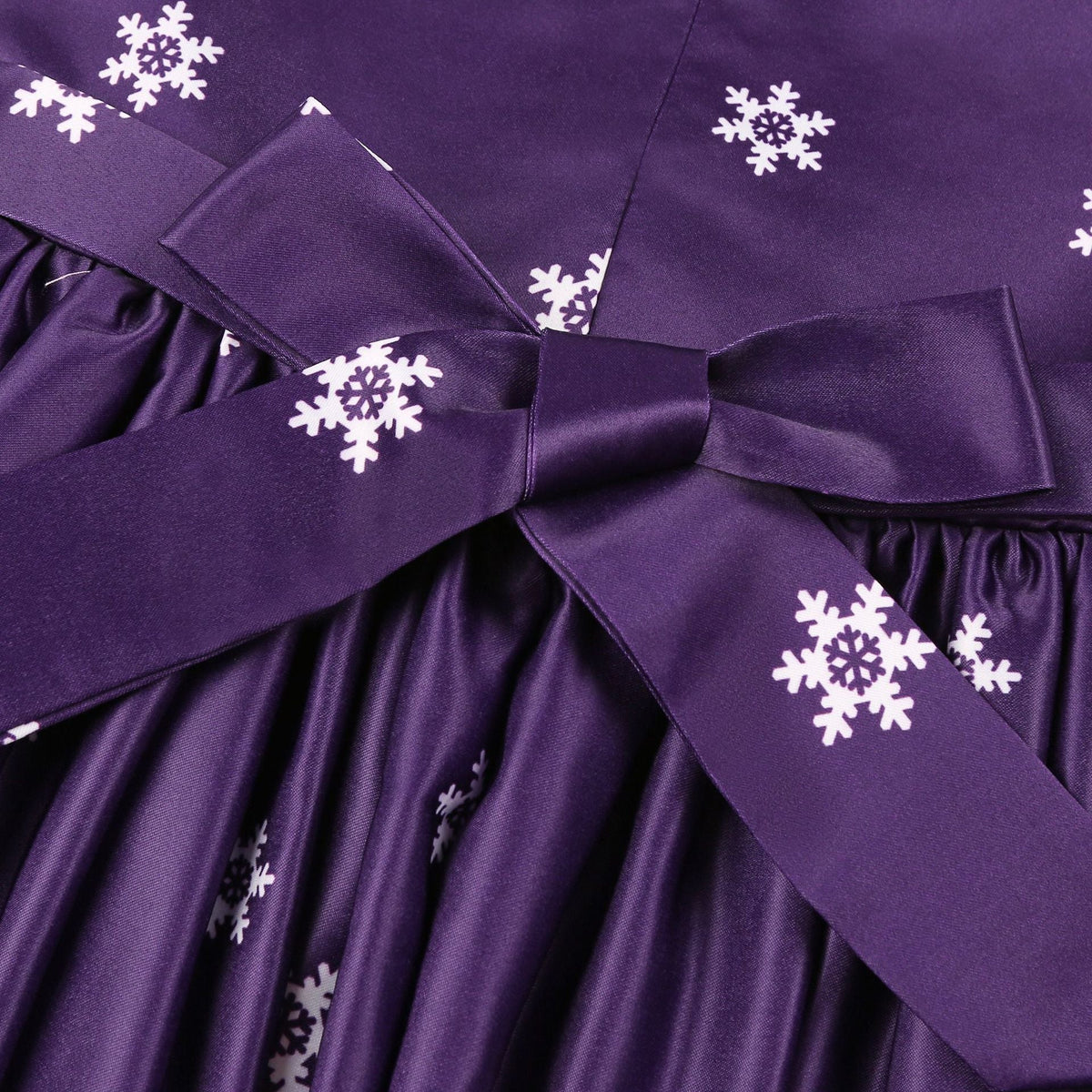 Girls' sleeveless Christmas dress with a bow and a festive print