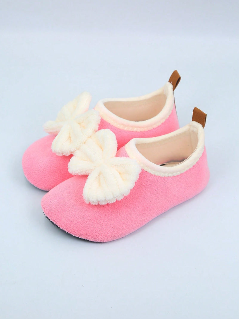 Slipper socks for kids with a soft lined upper, thin rubber sole and a pull-on loop at the heel - pink with bow