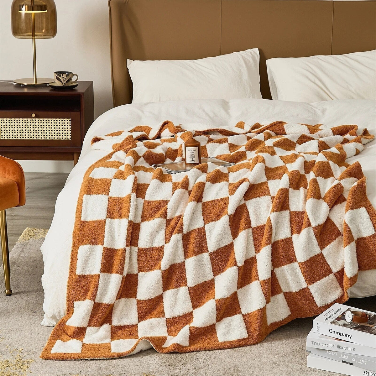 Knitted teddy throw with a checkerboard pattern over an armchair - burnt orange