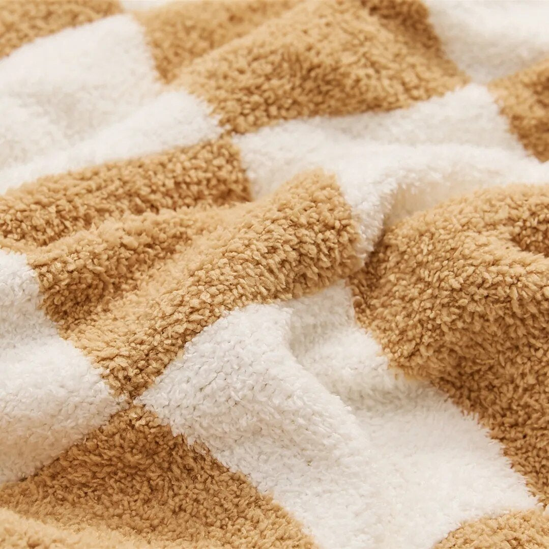 Knitted teddy throw with a checkerboard pattern over an armchair - view 2