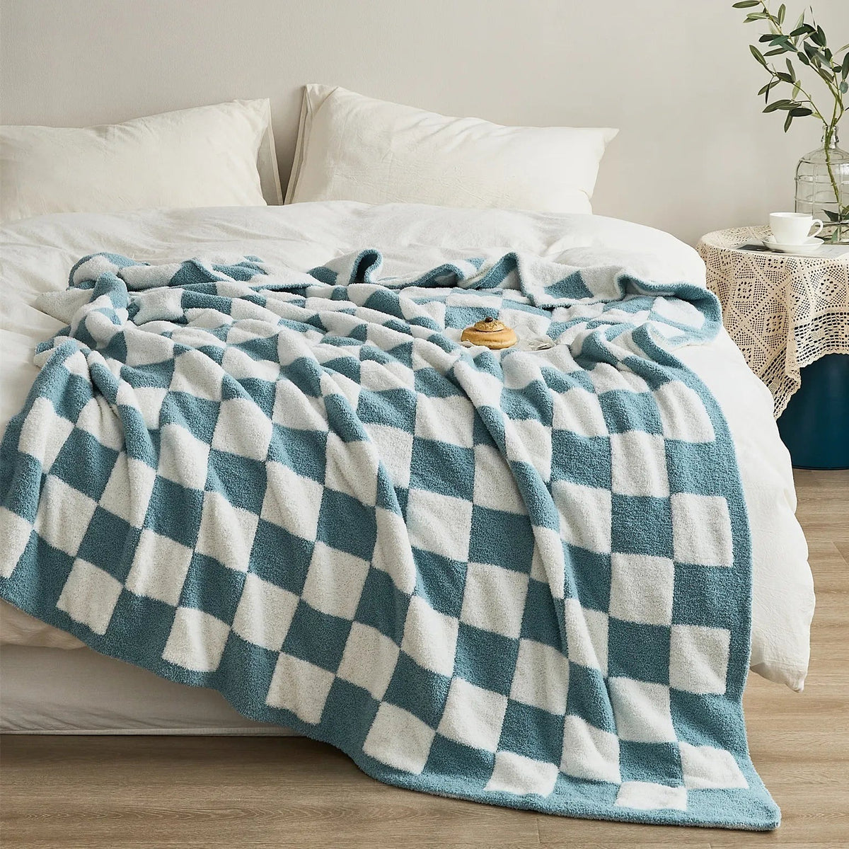 Knitted teddy throw with a checkerboard pattern over an armchair - petrol blue