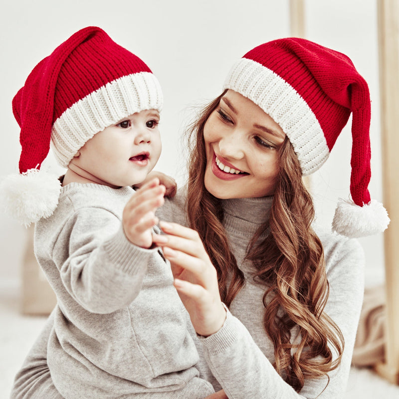 Red knitted Father Christmas hat with white cuff and pompom, parent and child