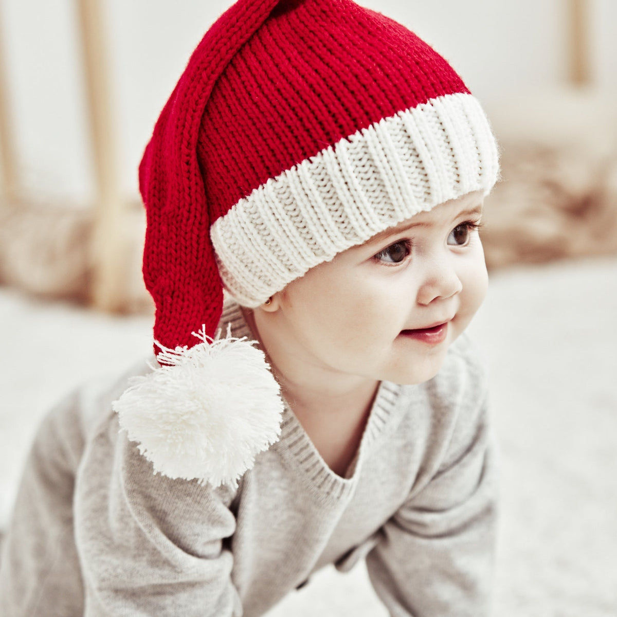 Red knitted Father Christmas hat with white cuff and pompom, parent and child
