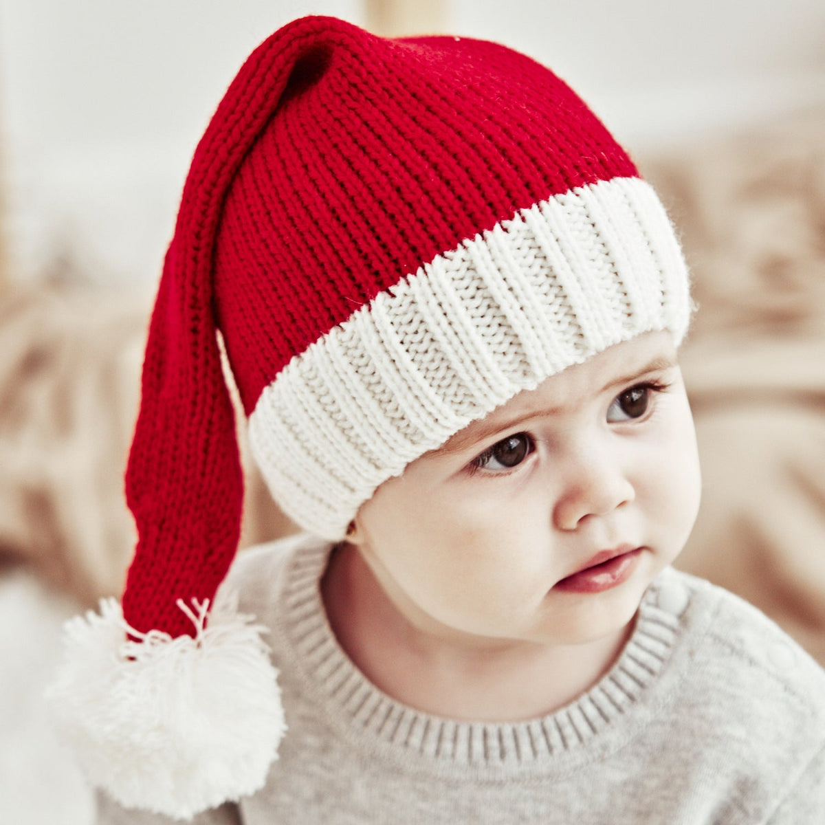 Red knitted Father Christmas hat with white cuff and pompom, parent and child