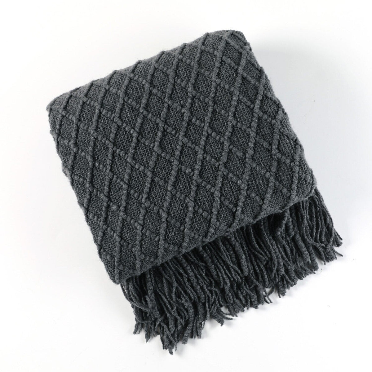 Knitted throw with a Scandinavian pattern and tassels over a chair - charcoal