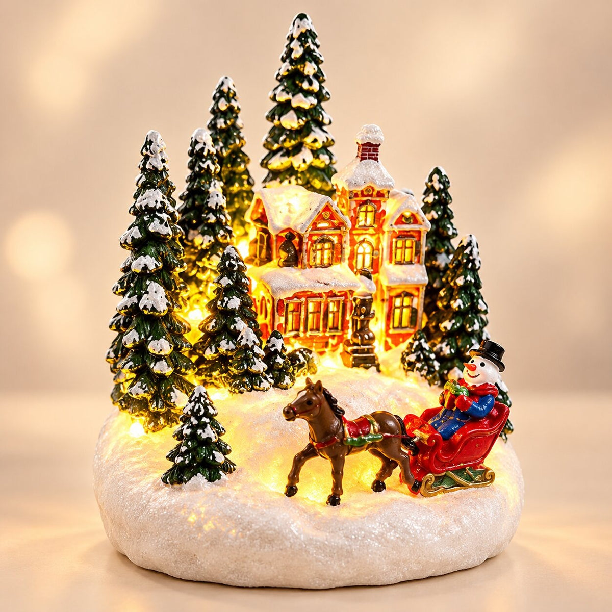 Light-up Christmas house with snow on the roof - winter village with sleigh