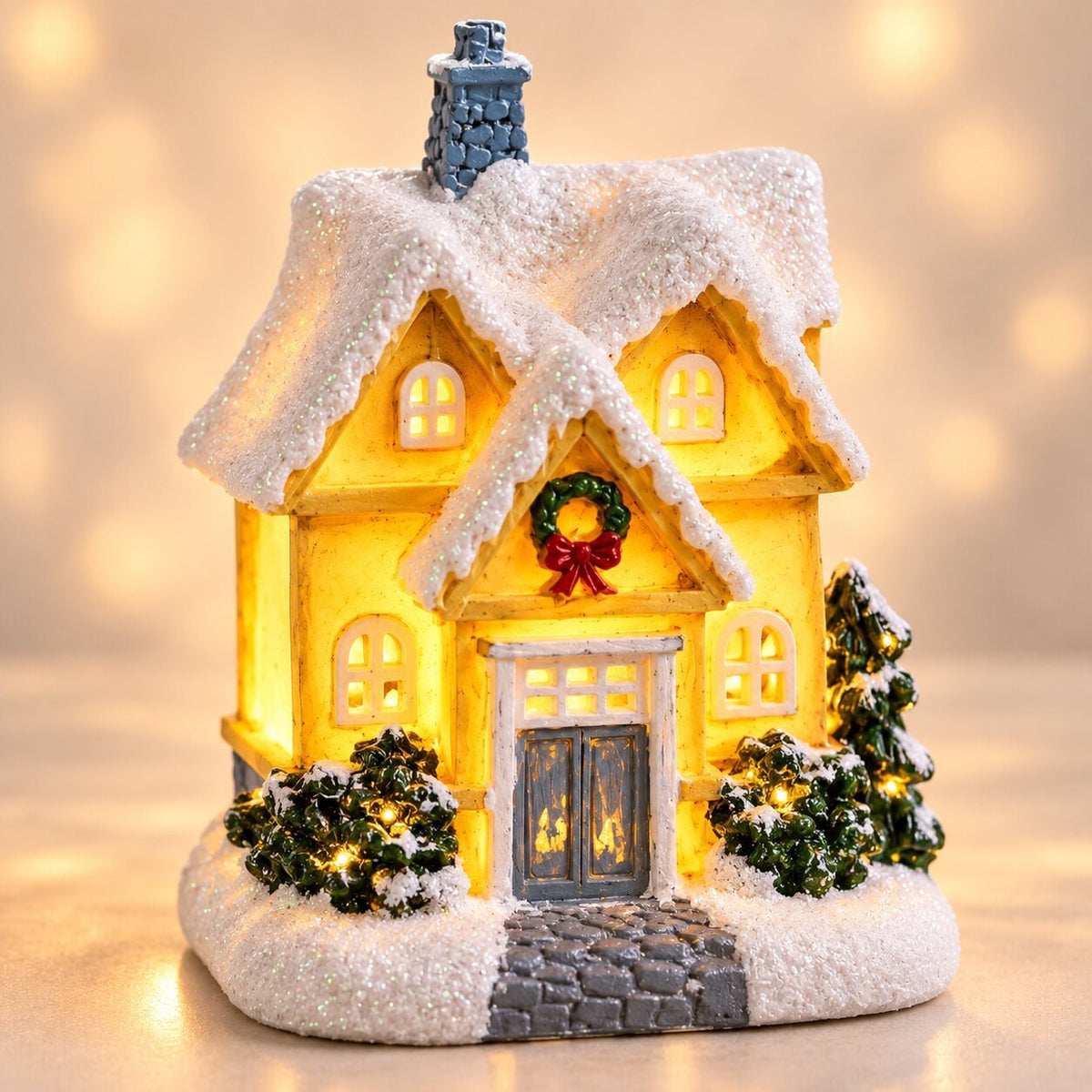 Light-up Christmas house with snow on the roof - snowy manor house