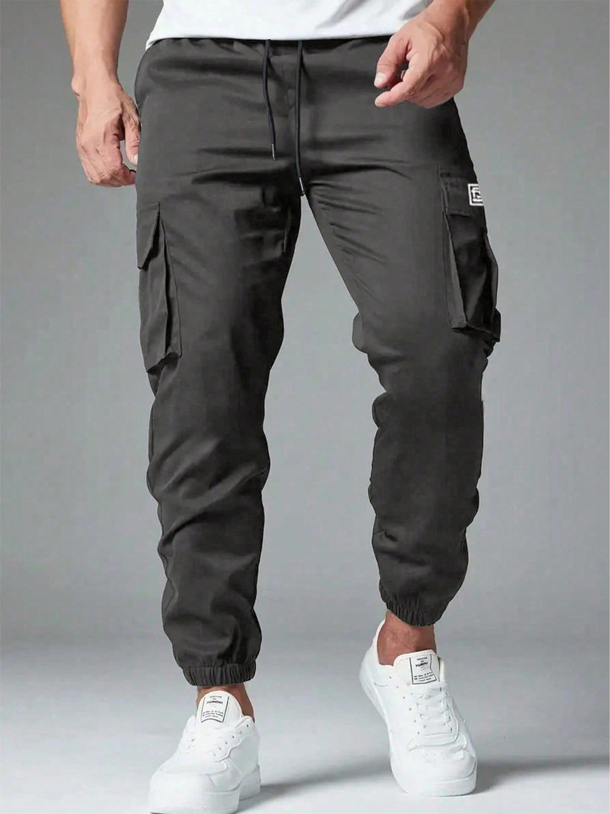 Cargo trousers for men with a drawcord waist, thigh flap pockets and elastic cuffs at the ankle - charcoal