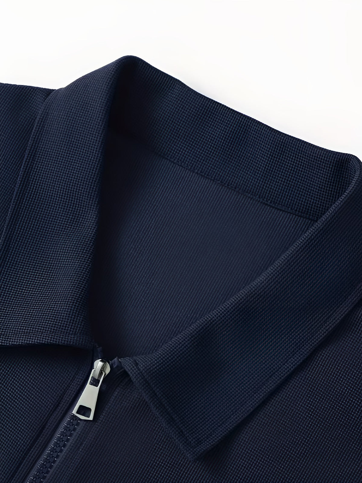 Close-up of the shirt collar and zip on the navy tracksuit jacket