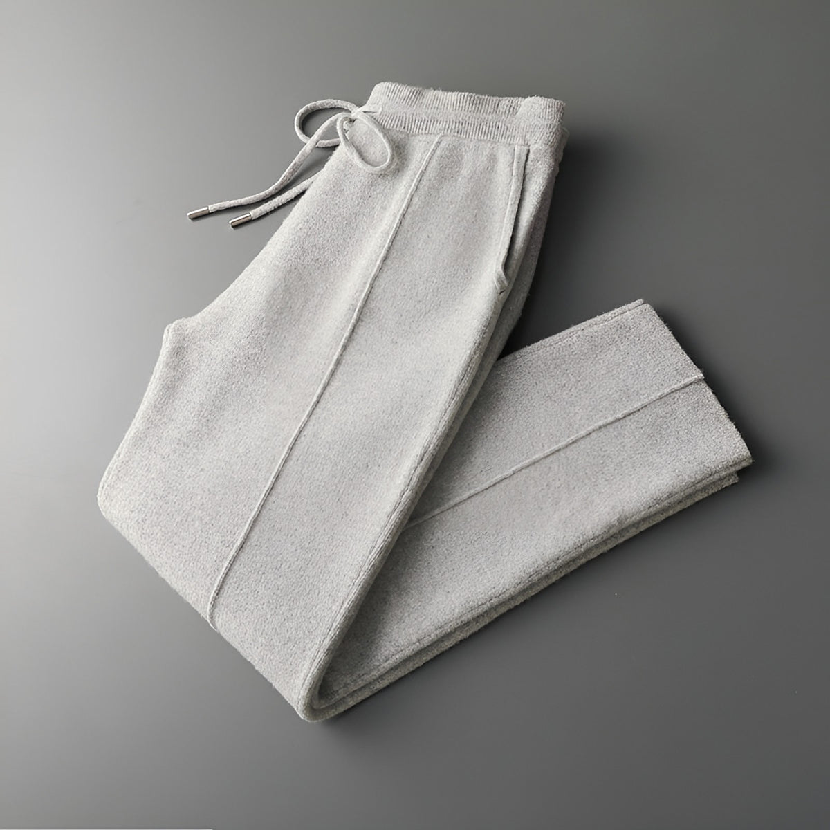 Men's knitted wool trousers in light grey, folded with drawstring waist