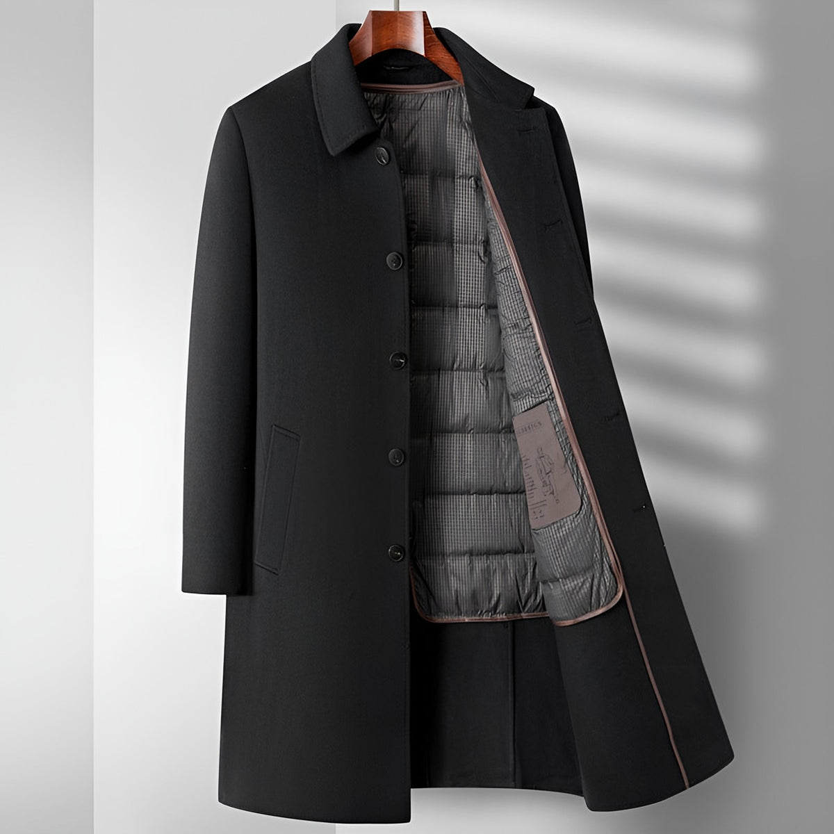 Men's long winter coat in black, worn open to show the quilted lining