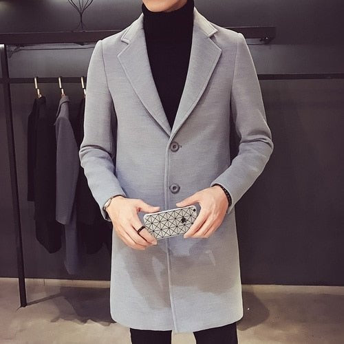 Men's light grey longline coat worn over a black roll neck
