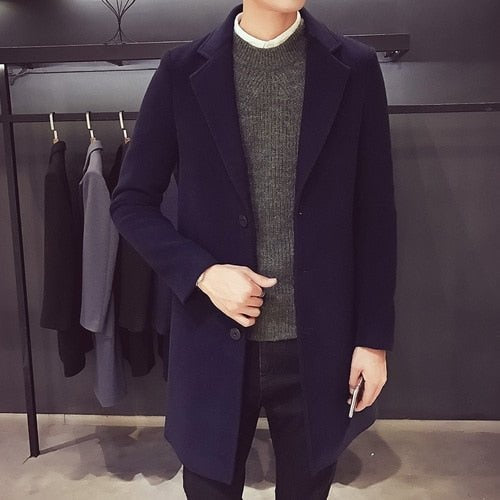 Men's navy longline coat worn over a grey jumper