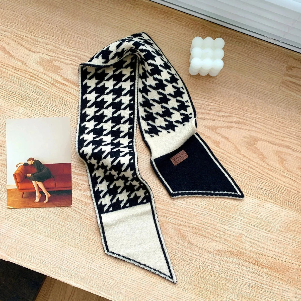 Women's narrow knitted scarf slipped through a small loop, with two plain pointed ends
