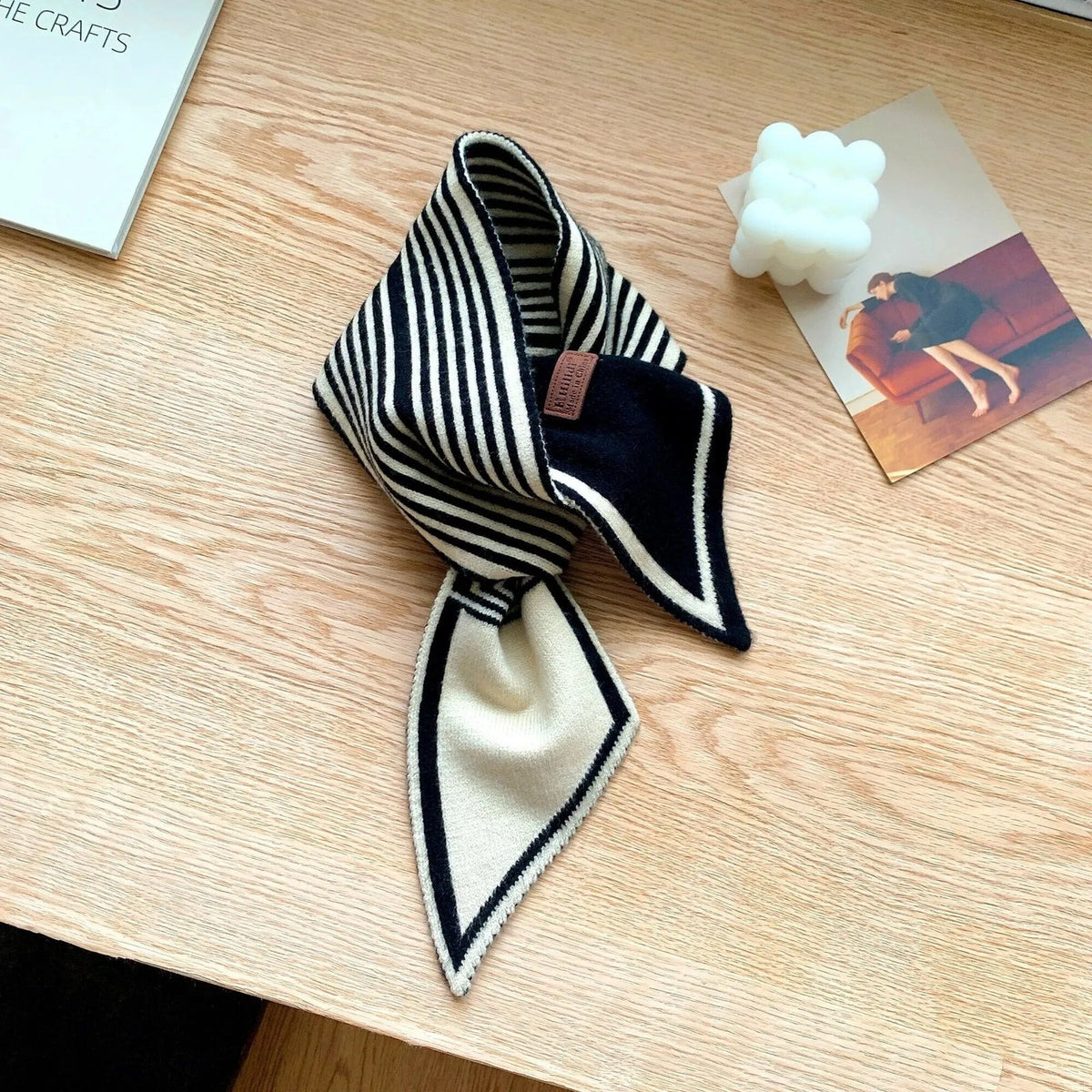 Women's narrow knitted scarf slipped through a small loop, with two plain pointed ends