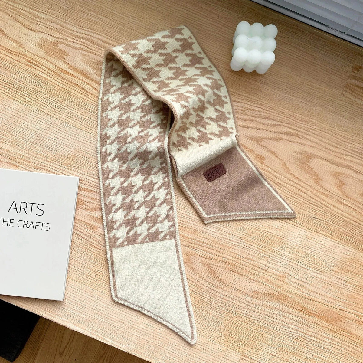 Women's narrow knitted scarf slipped through a small loop, with two plain pointed ends