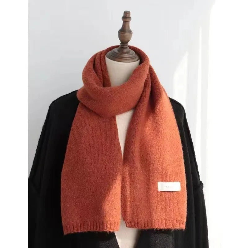 Women's narrow knitted scarf with ribbed ends and a small white label - rust orange