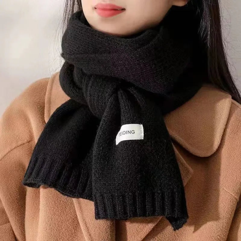 Women's narrow knitted scarf with ribbed ends and a small white label